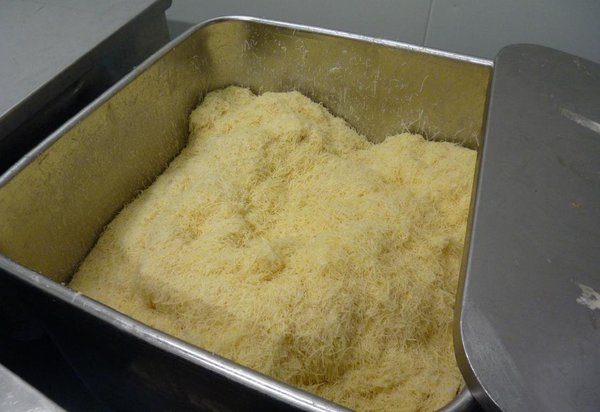 Les meules de comté sont ensuite coupées et râpées.