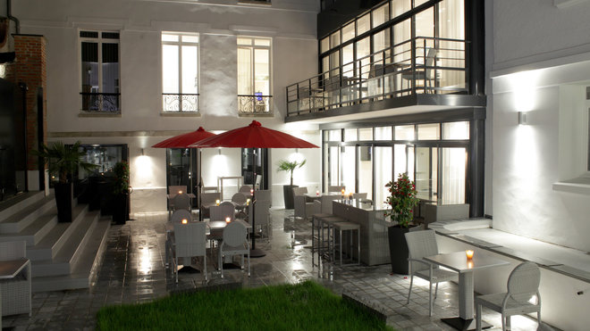 Autour du carré vert et des façades peintes en blanc, la terrasse offre aux beaux jours un espace extérieur supplémentaire aux clients de l’hôtel.