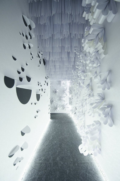 A l’entrée de la foire Graphispag de 2011 à Barcelone, les visiteurs sont accueillis par un tunnel blanc habillé entièrement de papier découpé de formes diverses, comme dans une jungle remplie d’obstacles.