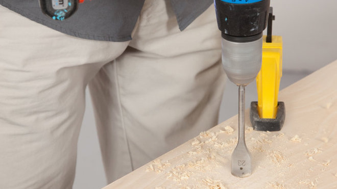 Etape 7 : À l’aide de la perceuse, équipée de la mèche anglaise, percez deux trous sur l’étagère du bas. Situés juste en dessous des emplacements de l’étagère du haut,  ils permettront à l’eau des pots du dessus de s’écouler correctement.