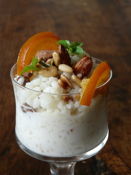 Rien de tel qu'un riz au lait de qualité, fait maison. En le surmontant d'écorces d'oranges confites, d'amandes et pignons caramélisés, il devient même chic.