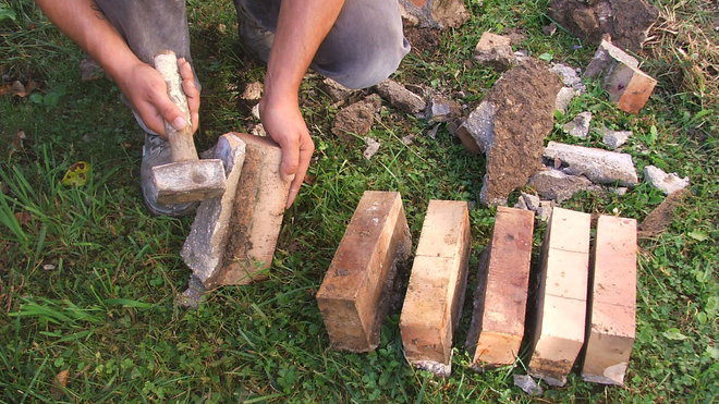 Etape 4 : Récupérer les anciennes briques non abîmées en enlevant, à l’aide d’une massette, le surplus de vieux béton. Ces briques seront réutilisées en alternance avec des pavés neufs.