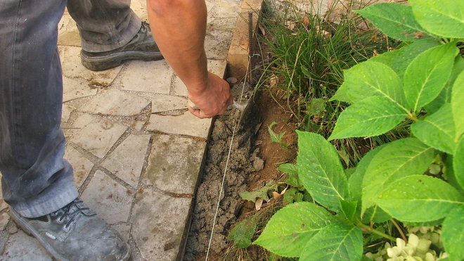 Etape 7 : Fabriquer un béton plus ou moins sec (5 volumes de sable, 2 volumes de ciment, 2 volumes d’eau). Étaler la préparation tout le long de la bordure, à même la terre. Progresser le travail par paliers de 1 mètre.