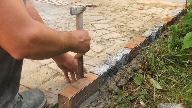 Etape 9 : La brique sera enfoncée en la tapotant légèrement avec le bout du manche en bois du marteau de maçon, dans le but de ne pas casser la brique, plus fragile que le pavé.