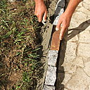 Etape 10 : Sur le côté extérieur, et tout le long de la bordure, réaliser un solin de béton ; le béton utilisé sera le même que celui utilisé lors de la mise en place des pavés. Effectuer cette opération à l’aide d’une truelle, en venant lisser le béton.