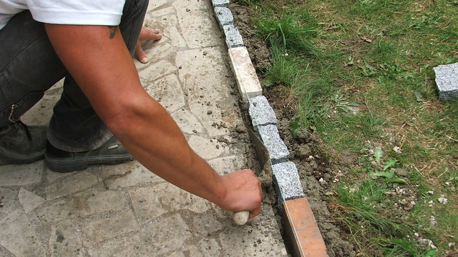 Etape 11 : Remplir de béton la petite distance entre l’allée et les pavés, dans le but de renforcer la prise ultérieure. Bien tasser le béton au fond de cet espacement.