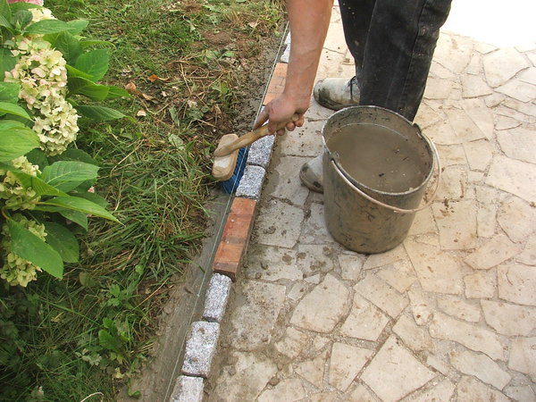 Etape 12 : Avec une brosse bien imbibée d’eau, lisser le solin extérieur, et ceci sur toute la longueur de la bordure. Attendre 24 heures avant le durcissement complet du béton ainsi que de sa prise.