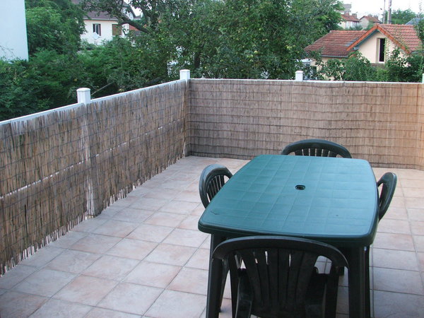 Avant: une terrasse bordée d'une canisse terne et banale.