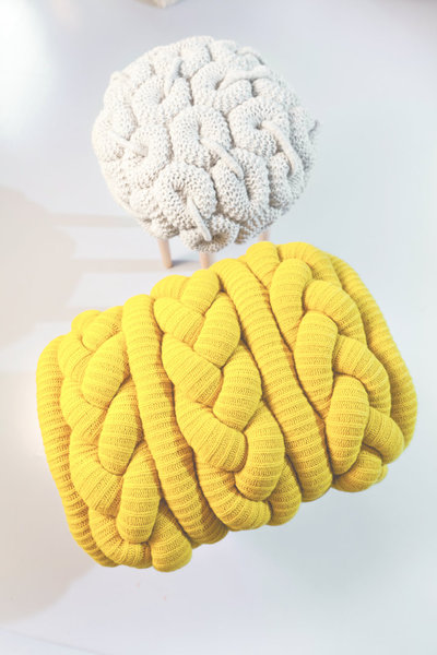 La designer textile irlandaise Claire-Anne O’Brien travaille la technique du tricot qu’elle applique à des surfaces inhabituelles, afin de réaliser des créations originales en laine, comme ces tabourets dont les assises quasi sculpturales sont habillées de complexes mailles surdimensionnées, enchevêtrées les unes aux autres.