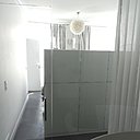 Un sol en béton ciré habille l’espace chambre et l’espace bain, pour créer une belle unité. La paroi en verre transparent laisse passer la lumière.