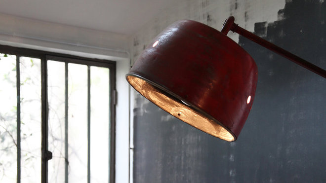 Le mur inachevé peint en noir prend des airs de toile peinte. Il crée un coin salon, et fait partie de l’atmosphère de l’atelier.