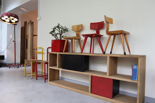 Sans fausse note, on trouve des chevets de pensionnat, une étagère en chêne massif et une lampe industrielle ; le tout est harmonisé par des touches de rouge.