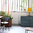 Devant la verrière de l’atelier donnant sur la cour, un coin bureau est installé avec des casiers industriels patinés, un bureau des années 50 et une chaise signée Jean Prouvé.