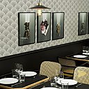 L’atmosphère intimiste des tables est apportée par le soubassement laqué en noir,  le papier peint japonisant et les touches de jaune sur les fauteuils en cannage.