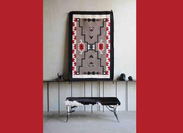 Ce banc aux pieds en cornes de Long Horn est recouvert d’une peau de vache noire et blanche. Banc texan à La Cabane de l’Ours.