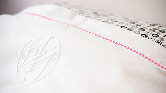 Une housse de couette confectionnée à partir d’un drap ancien brodé et doublé, orné d’un galon rose fluo, gris ou noir. La parure de lit pour enfants sages… Ou pas ! A partir de 150 €. L’Hirondelle.