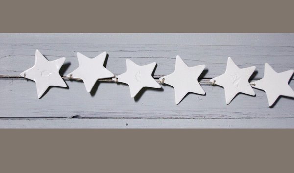 Doux et délicat, un mobile comprenant 6 étoiles en porcelaine blanche accrochées sur un fil de lin. Chaque mobile est une pièce unique fabriquée par Justine Lacoste. H 65 cm. 30 €. Etoiles en porcelaine. Love Creative People.