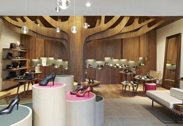 En menant à bien le projet Bocage, Eric Gizard a donné une véritable identité à la marque. Dans les boutiques à l’architecture nordique, un arbre en plaqué occupe une place centrale, sous lequel on s’assoit pour essayer les chaussures. Au plafond, des boules en verre apportent une touche féerique. Des touches de couleurs, changeantes au fil des saisons, rythment l’espace.