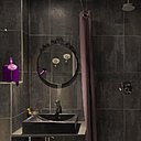Les salles de bains sont aussi élégantes que les chambres, avec une décoration très simple dans des tons pourpre, qui se marient parfaitement avec un carrelage mural gris anthracite.