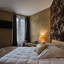 Une chambre bohème chic, avec sa tête de lit façon dentelle, et ses coussins et ses murs dorés.