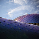 Le Pavillon de Services est chapeauté d’un toit atypique de tuiles en inox iridescent, qui décline des teintes changeantes en fonction de la lumière : vert, bleu, rose, ses écailles métalliques miroitent comme la carapace d’un scarabée.