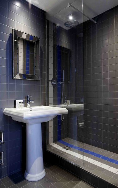 Les salles de bains utilisent le même code couleur, le gris et le bleu. Hôtel Mademoiselle.