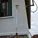 Etape 19 : A défaut d’échafaudage ou de grande échelle, la première couche de peinture de finition spéciale façade sera appliquée au rouleau façade 18 mm monté sur une perche pour les grandes hauteurs.