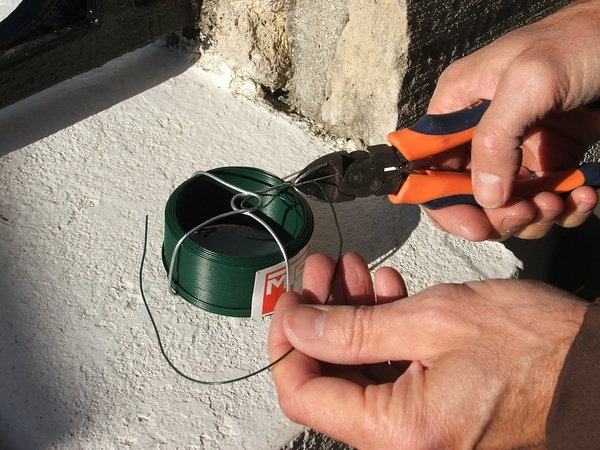 Etape 4 : Découper des morceaux de fil souple de grillage de jardin en bobine de diamètre 1 mm (des longueurs plus ou moins 15 cm), qui serviront à la fixation aux travers des œillets de fixation du brise-vue.