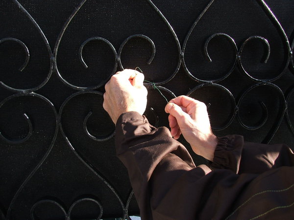 Etape 7 : Renforcer le brise-vue avec une fixation de fil souple sur le milieu du panneau, en venant se prendre sur la ferronnerie. Le fil souple s’enfonce facilement au travers de la matière, sans pour autant l’abîmer.