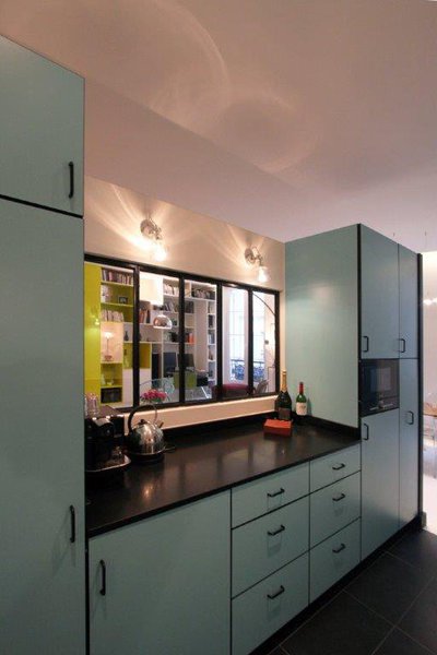 La cuisine de style années 1950 en formica offre sa touche rétro et une vue sur la pièce à vivre.