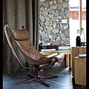 Le sol est recouvert de dalles de pierre provenant d’une carrière voisine. Et le design scandinave s’invite au salon avec ce fauteuil en cuir vintage.