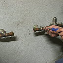 Etape 11 : les raccords flexibles nécessitent des raccords mâles. Il est donc nécessaire de démonter le système qui a permis l’installation de l’ancien filtre. Dévisser le collier de serrage du tuyau en cuivre à l’aide d’un tournevis.