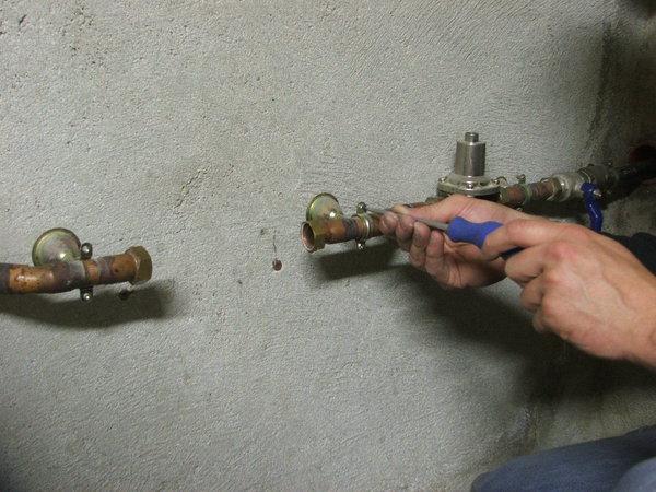 Etape 11 : les raccords flexibles nécessitent des raccords mâles. Il est donc nécessaire de démonter le système qui a permis l’installation de l’ancien filtre. Dévisser le collier de serrage du tuyau en cuivre à l’aide d’un tournevis.