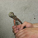 Etape 14 : à l’aide d’une pince coupante, enlever la tige filetée et la rosace en forme de cloche du collier de serrage restant.