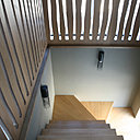 L’escalier en chêne est encadré dans une cage ajourée qui fait écho au porte-manteau de l’entrée.