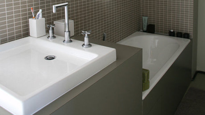 La salle de bains de la chambre d’amis étroite, joue le gain de place, avec des aménagements compacts.