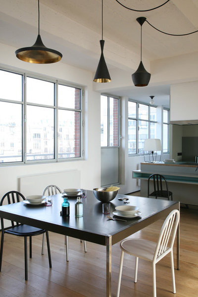 Un jeu de trois suspensions Beat Light de Tom Dixon éclairent la table de salle à manger.