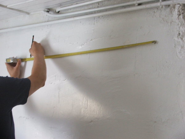 Etape 4 : Poser le mètre le long de la ligne horizontale, puis marquer le deuxième trou à 1 mètre d’intervalle, par rapport au premier trou de fixation.