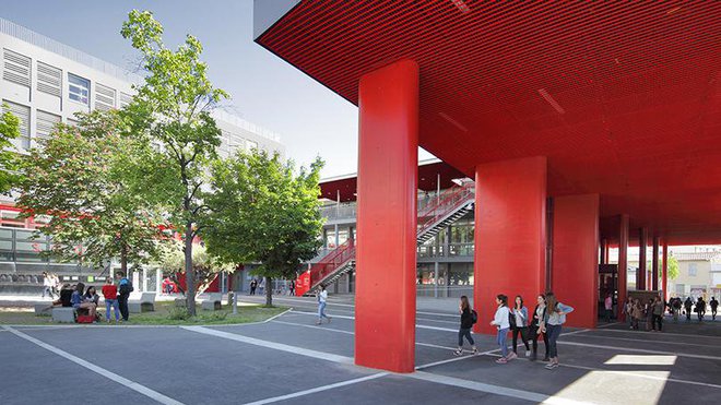 Le vaste porche théâtralisé assure désormais plusieurs fonctions. La grande sous-face en résille métallique rouge du laboratoire devient un vaste porche. Il abrite le nouveau hall d'entrée conçu dans une courbe vitrée, et prolonge la salle de conférence. Il offre aussi aux élèves de l'établissement le préau couvert qui leur manquait. La lasure rouge des poteaux du porche accompagne le cheminement depuis la rue jusqu’à la cour. Le vaste porche théâtralisé assure désormais plusieurs fonctions. La grande sous-face en résille métallique rouge du laboratoire devient un vaste porche. Il abrite le nouveau hall d'entrée conçu dans une courbe vitrée, et prolonge la salle de conférence. Il offre aussi aux élèves de l'établissement le préau couvert qui leur manquait. La lasure rouge des poteaux du porche accompagne le cheminement depuis la rue jusqu’à la cour.