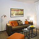 Un salon aux tons chauds et gourmands, marron glacé et orange. Une décoration moderne avec des sièges et des meubles aux formes géométriques, mais sans angle saillant. On a privilégié les formes courbes et arrondies. Un salon aux tons chauds et gourmands, marron glacé et orange. Une décoration moderne avec des sièges et des meubles aux formes géométriques, mais sans angle saillant. On a privilégié les formes courbes et arrondies.