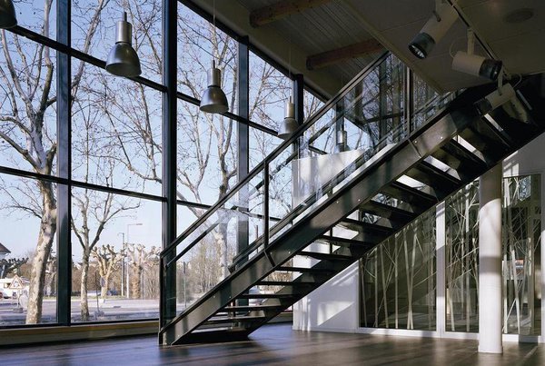 Au rez-de-chaussée, on trouve le hall d’exposition et la médiathèque qui donnent sur un espace paysager. Lumière et simplicité sont les maîtres mots du projet. Le parquet en bois s’associe aux grandes baies vitrées pour créer une atmosphère agréable.