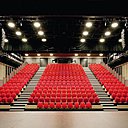 Dans la salle de spectacle, les reflets dorés de la vêture métallique symbolisent la richesse de la connaissance. Les panneaux aux tons cuivrés donnent à l’espace des allures de trésor vivant.