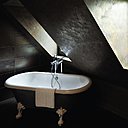 Au 6ème étage de l’hôtel, les murs sont recouverts d’une couleur bronze patinée aux effets de tadelakt marocain. Mi-contemporaine, mi-classique, la baignoire, dessinée par Stella Cadente pour l’éditeur belge Aquamass, s’intègre parfaitement à la chambre.