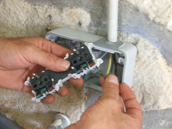 Etape 13 : Sur la barrette de branchement, enfoncer le fil de phase sur son emplacement.