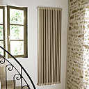 Intégration parfaite d’un radiateur Vuelta  de style traditionnel dans une maison ancienne rénovée avec des matériaux anciens, dans un coloris ton Pierre pour se fondre discrètement dans l’harmonie générale.