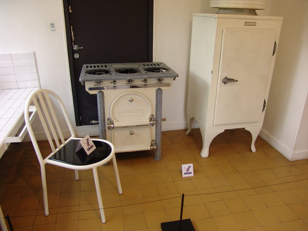 Chaise de cuisine, d’après Robert Mallet-Stevens, 1931, édition postérieure en métal et bois. Centre des monuments nationaux, Villa Cavrois, Croix. Réfrigérateur à compression Frigéco, Général Electric Compagny, 1930, en métal et plastique. Paris, Musée des arts et métiers, Cnam, In. N° 35283. Machine à laver le linge triomphe BB type AB26. Chauveau Frères et compagnie, vers 1925-1945, en métal et caoutchouc. Paris, Musée des arts et métiers, Cnam, Inv. n°32068.