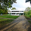 Implantée sur un terrain dégagé et sans contrainte urbaine, la Villa Savoye est une maison de week-end entourée d’arbres qui cachent les constructions avoisinantes, tout en dessinant une ceinture végétale protectrice.