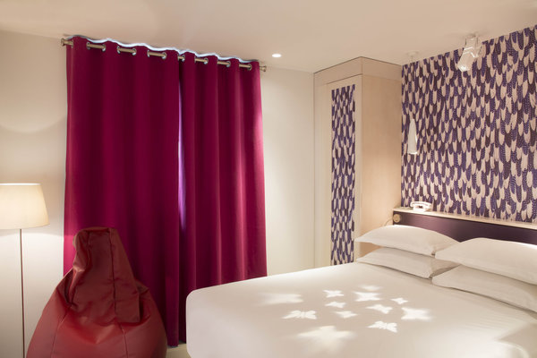 Un papier peint (Hermès) expressif qui suffit à lui seul pour créer une ambiance « Plume », associé à un simple uni en contraste.