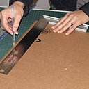 Etape 1. Dans le carton double-cannelure, découpez une plaque de 60 cm x 39 cm, avec les cannelures parallèles au côté de 60 cm. Utilisez l’équerre de menuisier pour effectuer des découpes à angle droit.