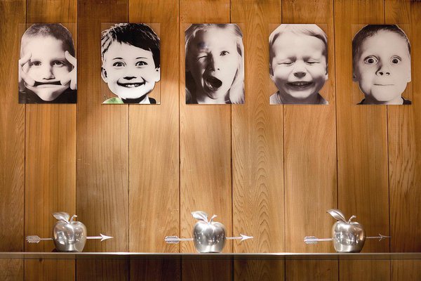 Le Paradis du Fruit Roots vous fait pénétrer dans un monde enfantin et imaginaire. Au mur, d’espiègles portraits d’enfants grimaçants et des pommes percées d’une flèche faisant référence à la légende de Guillaume Tell, héros de l’indépendance Suisse, qui releva avec succès le défi de tirer un carreau d’arbalète dans une pomme placée sur la tête de son fils.